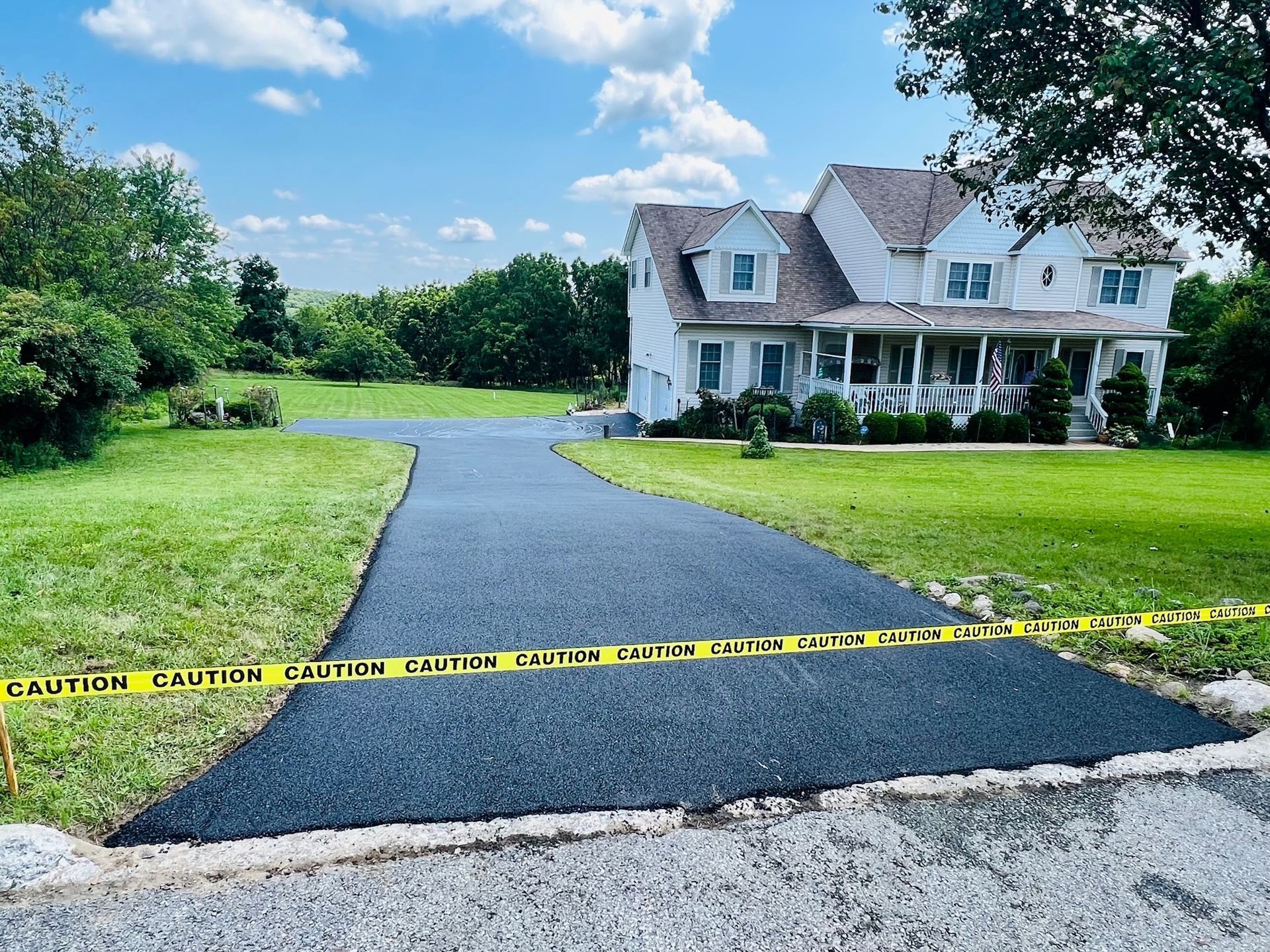 asphalt driveway with yellow tape