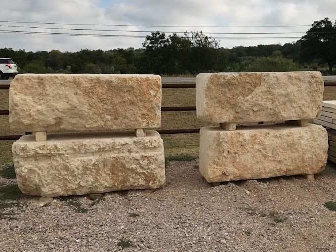 Two large stone blocks are sitting next to each other on a gravel road.