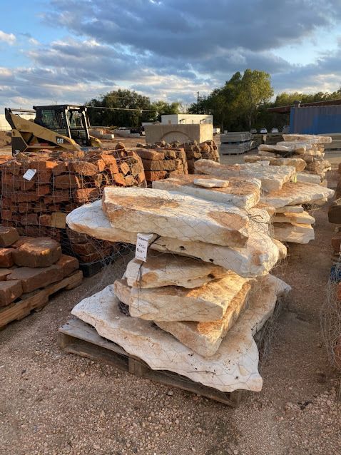 A pile of rocks sitting on top of a wooden pallet in a yard.