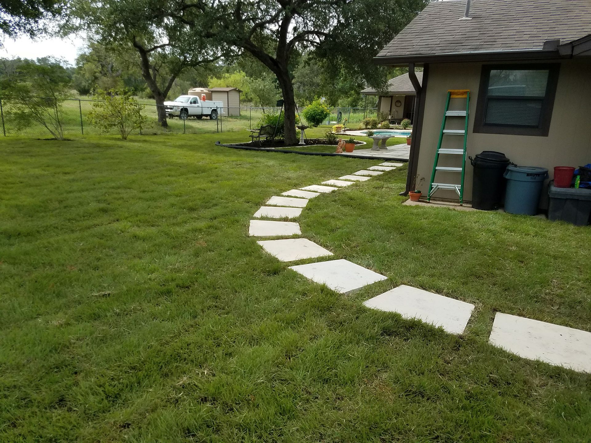 A lawn with a stone walkway leading to a house