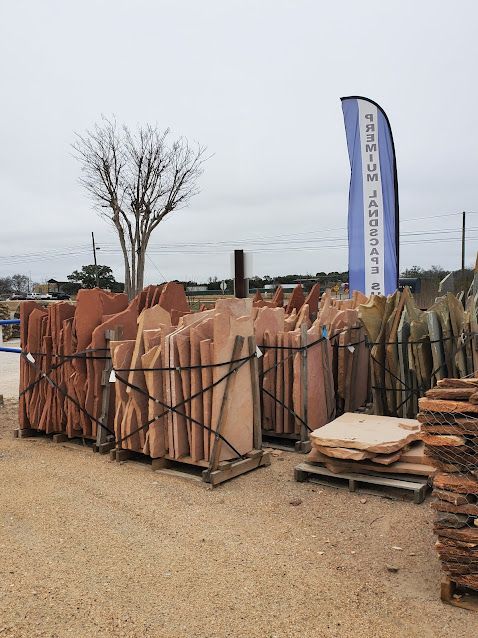 A bunch of rocks are stacked on top of each other in a yard.