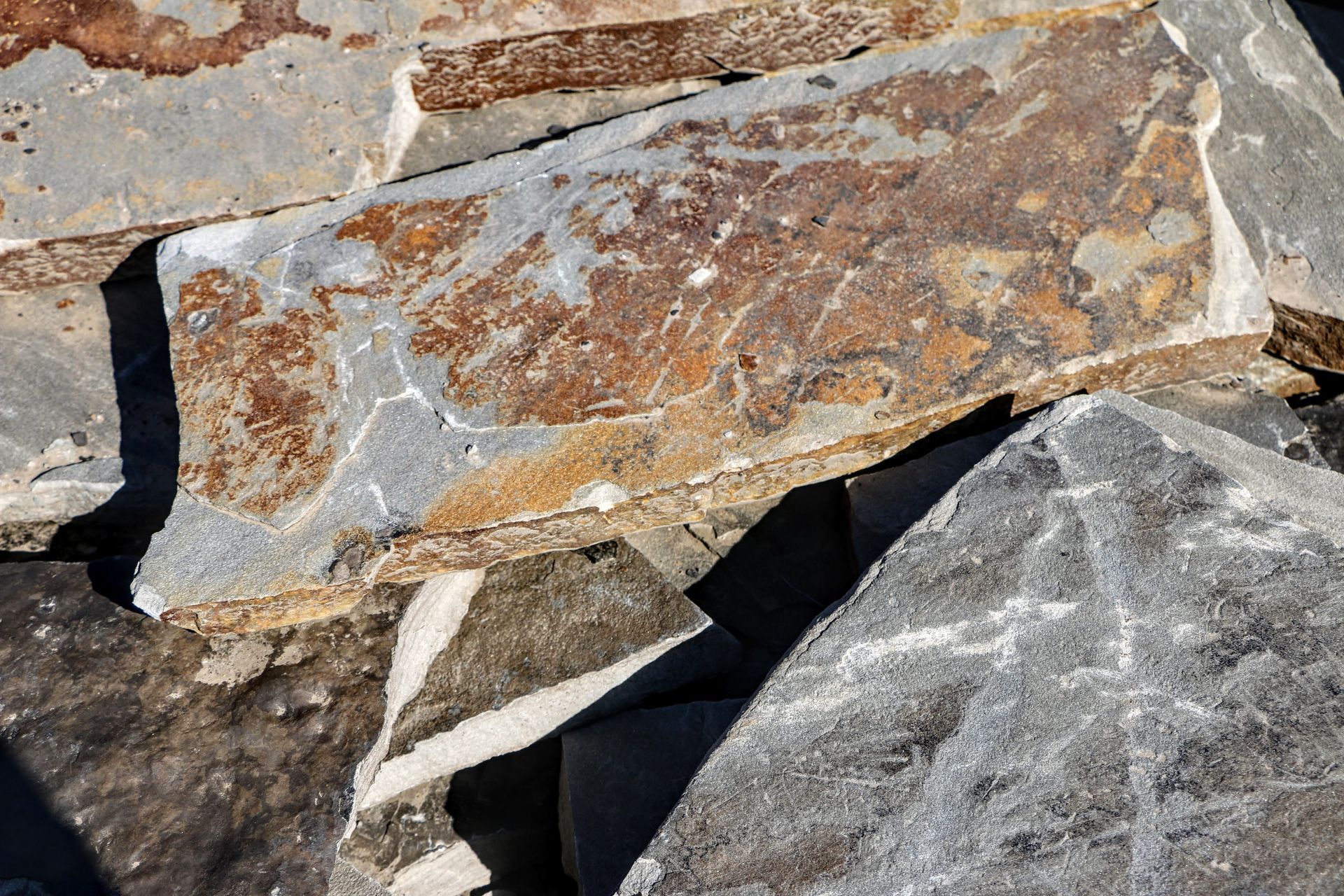 A pile of rocks of different sizes and colors are stacked on top of each other.