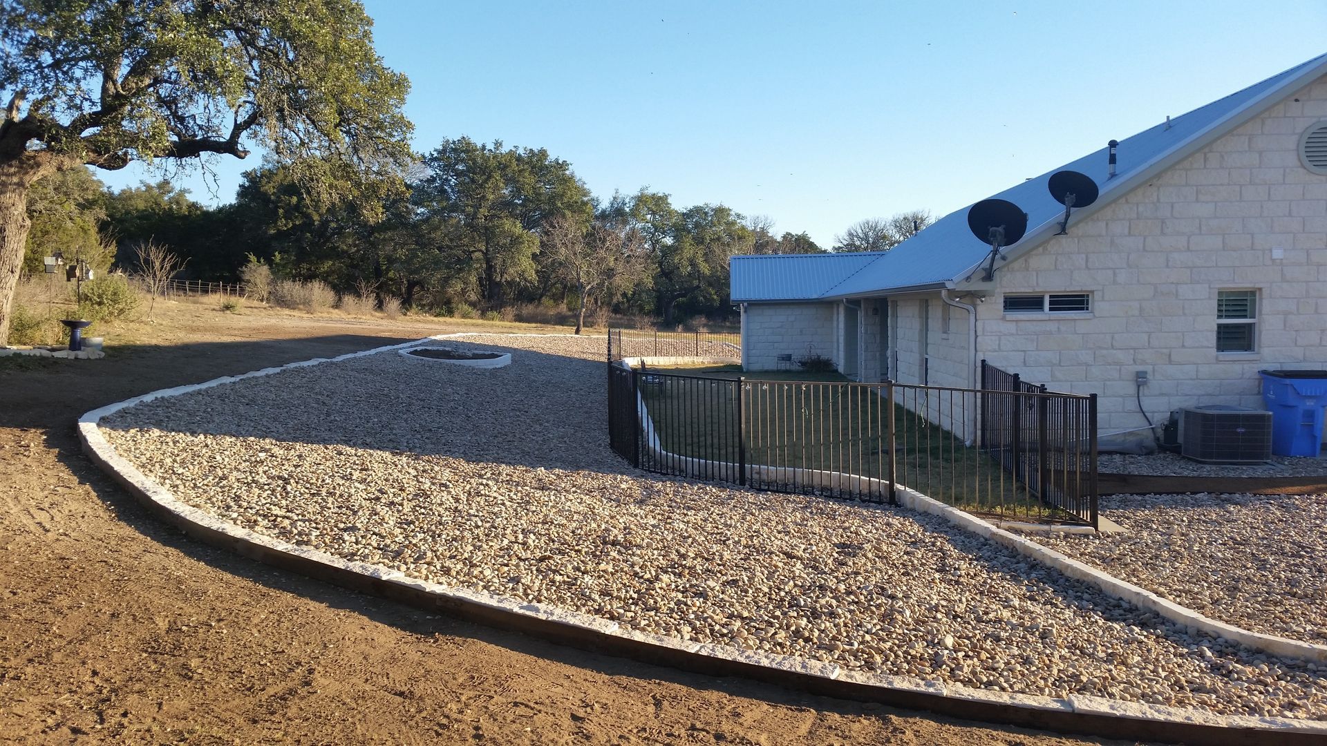 A white house with a gravel driveway in front of it.