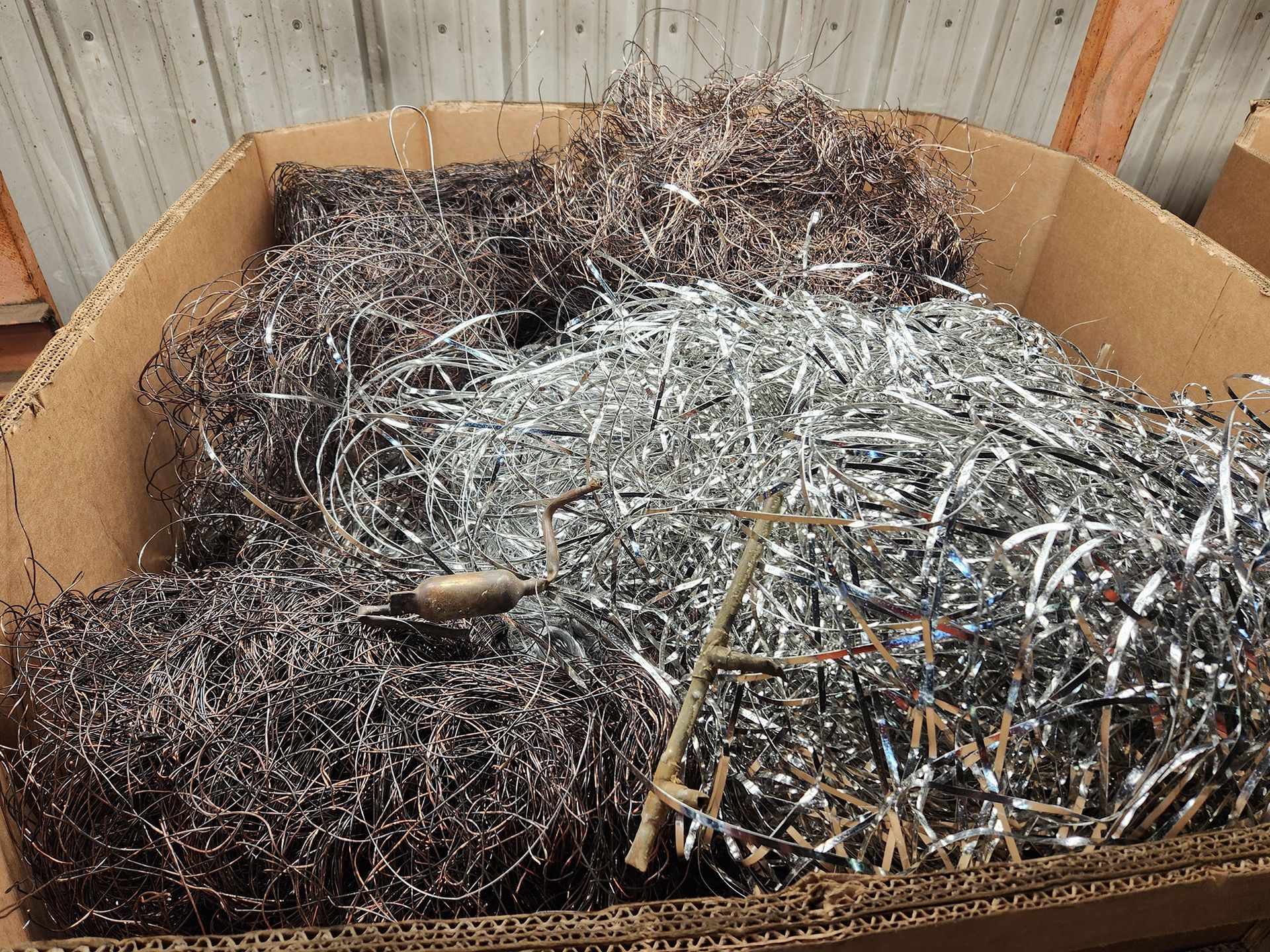 A cardboard box filled with a pile of shredded metal.