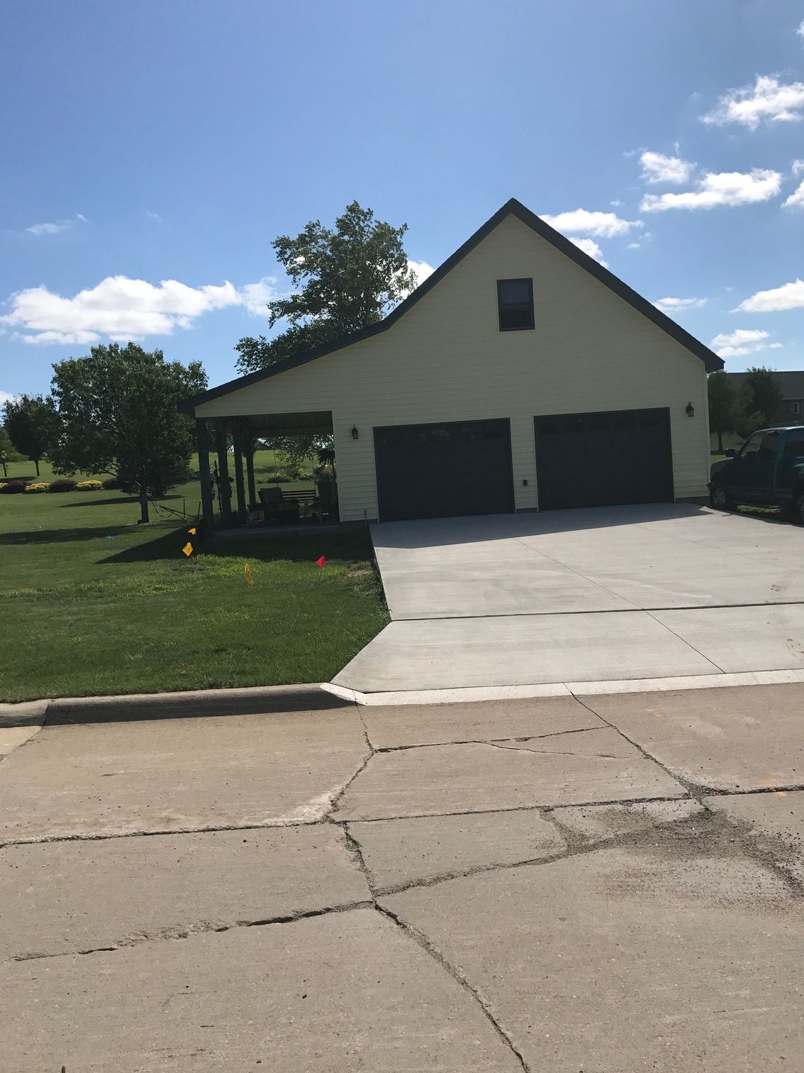Suburban house with a garage, concrete driveway, and a cloudy blue sky