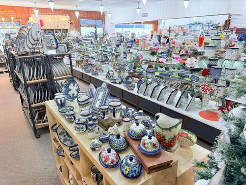 Display of colorful ceramic dishes and teapots in a bright pottery shop