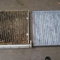 A dirty air filter and a clean air filter are sitting next to each other on a table.