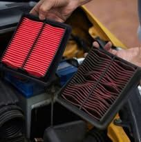 A person is holding two air filters in their hands.