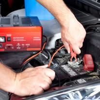 A person is charging a car battery with a charger.