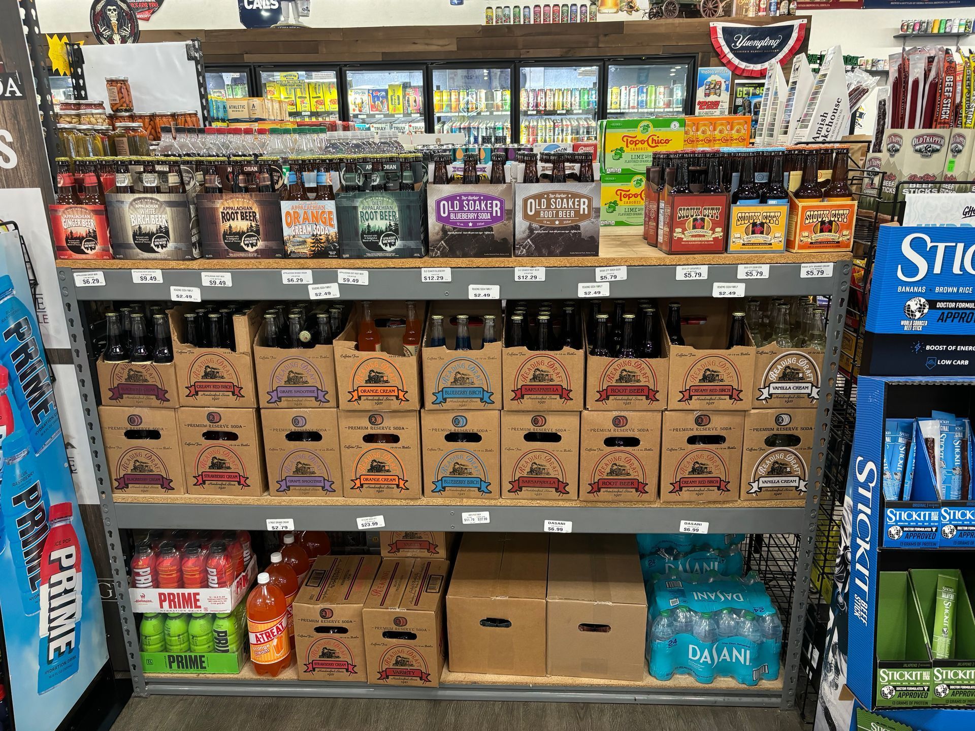 A store shelf filled with boxes of beer and soda.