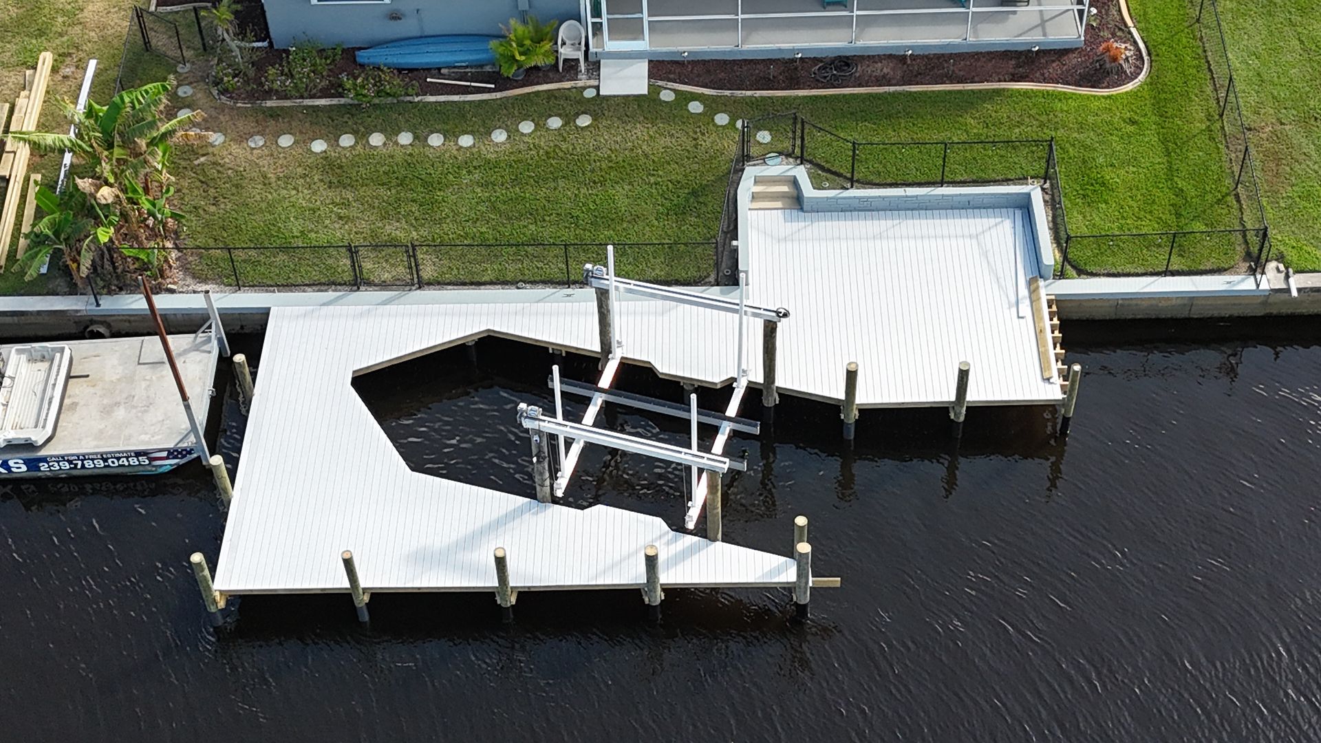 An aerial view of a dock with a house in the background