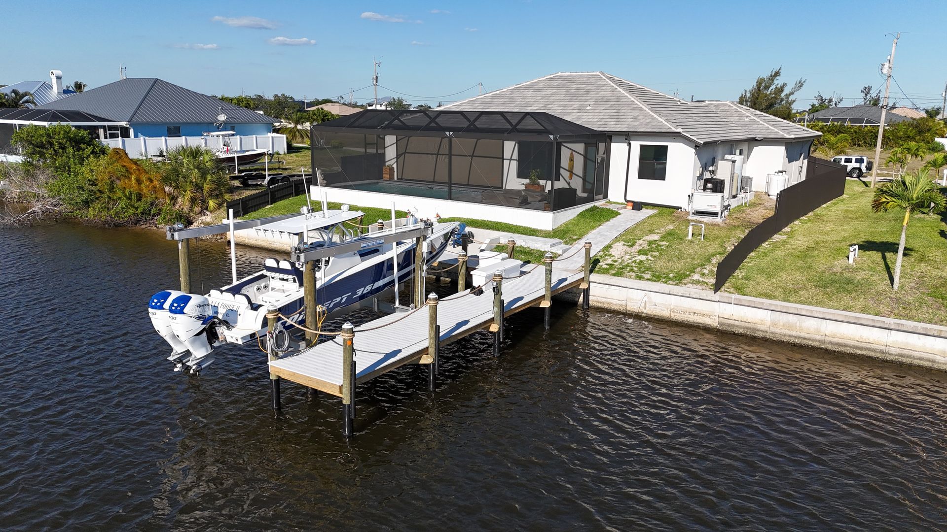 An aerial view of a house with a boat docked in front of it.