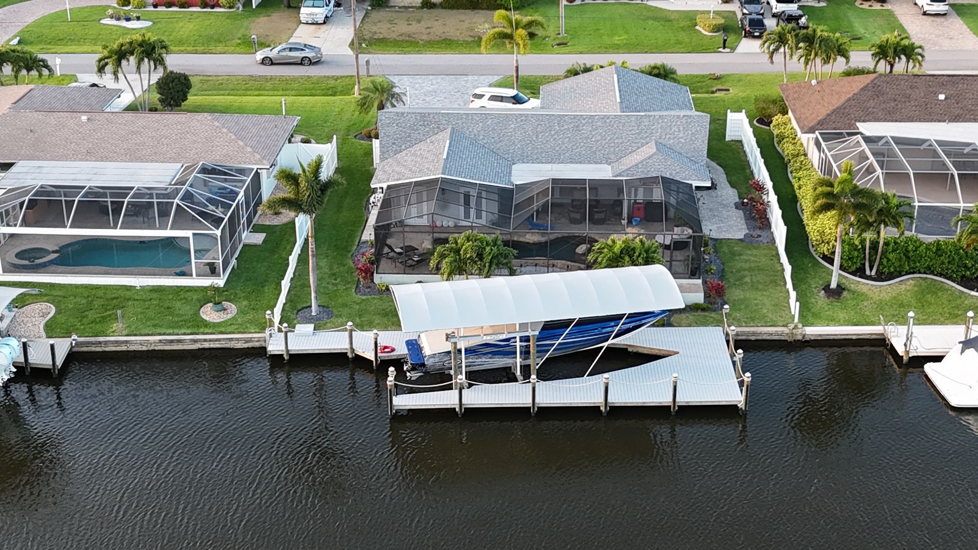 An aerial view of a house next to a body of water