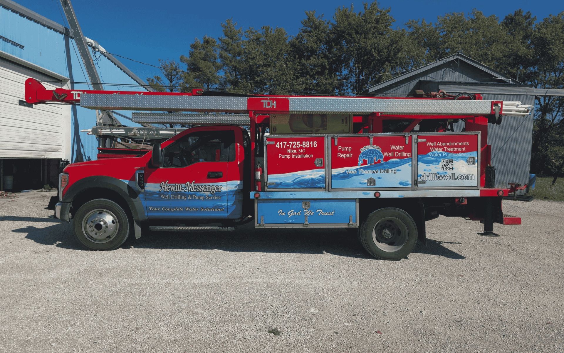 Red and blue water well service truck parked outdoors.