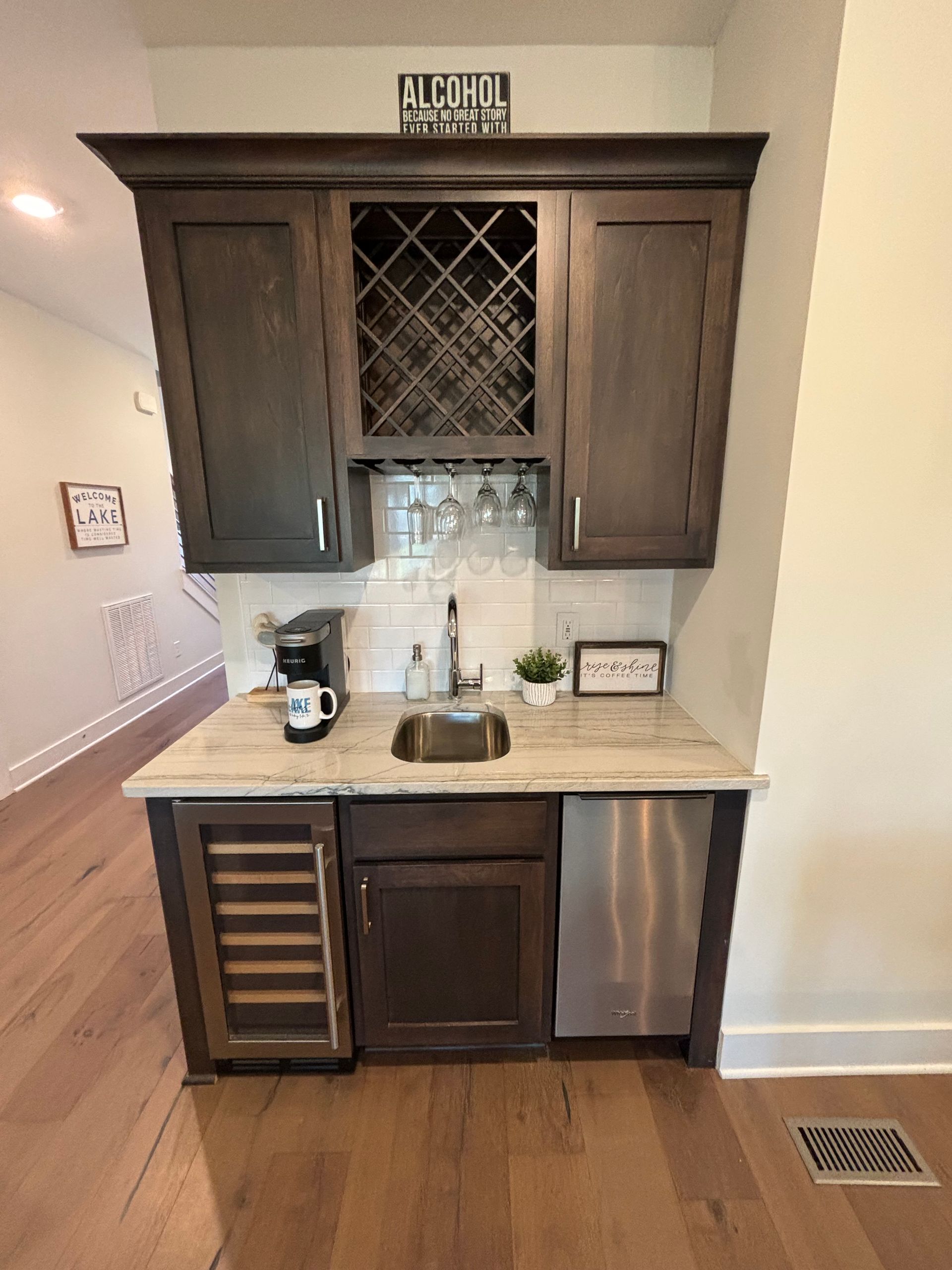 Dark wood bar cabinet with a sink, wine rack, and appliances.