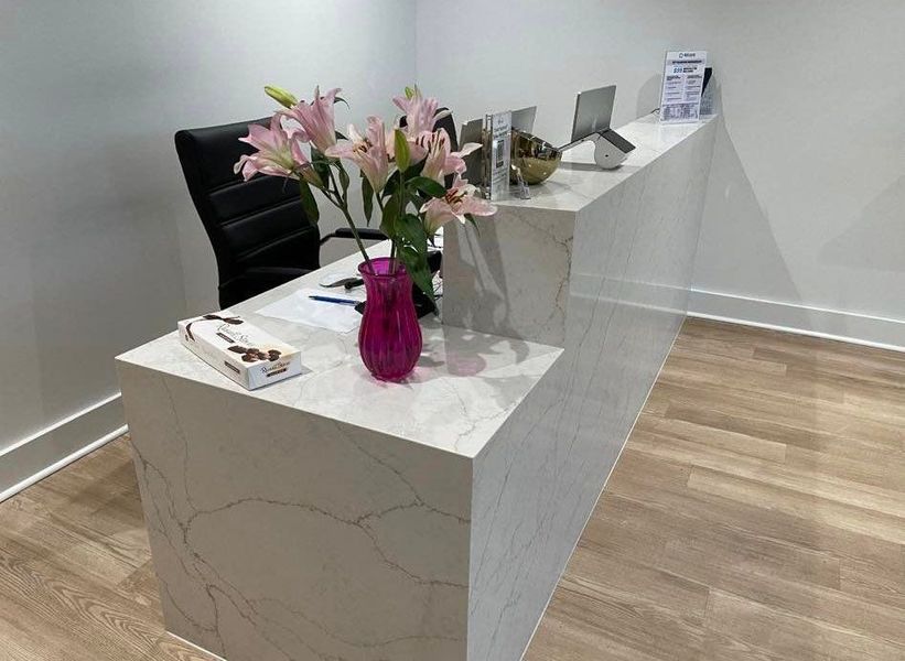 Reception desk with a flower arrangement and chocolates.