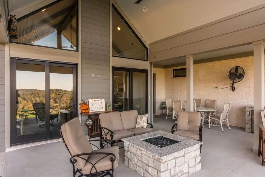 Covered patio with seating area, fire pit, and view of landscape.