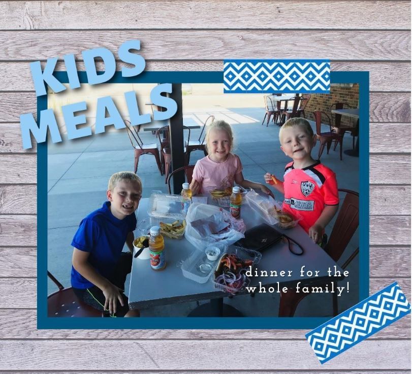 A picture of three children sitting at a table with the words kids meals above them
