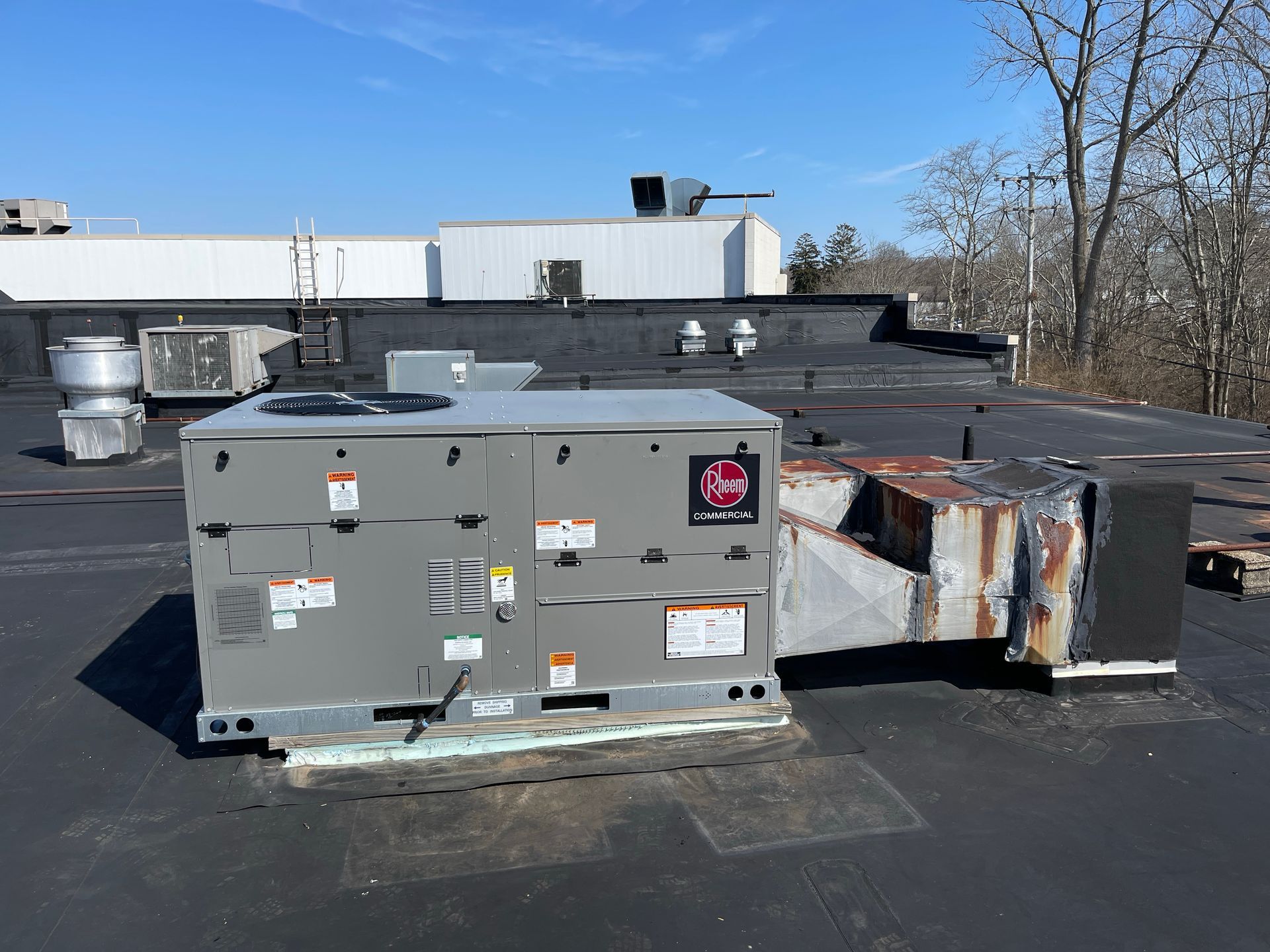 A large air conditioner is sitting on top of a roof.