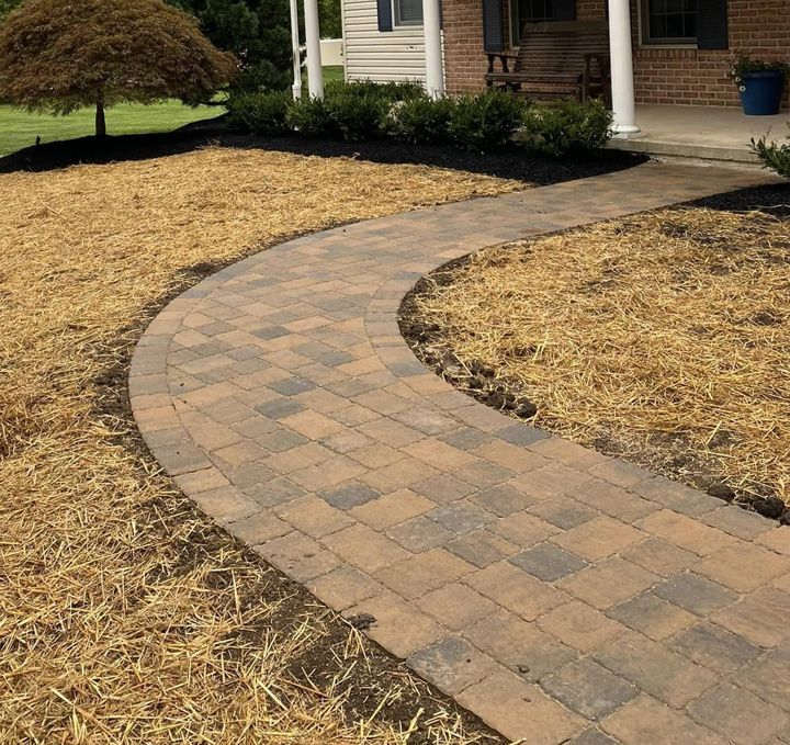 A brick walkway in front of a brick house
