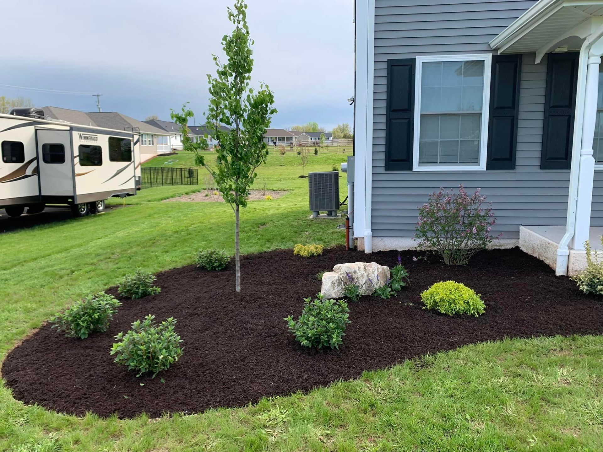 A house with a trailer parked in front of it.