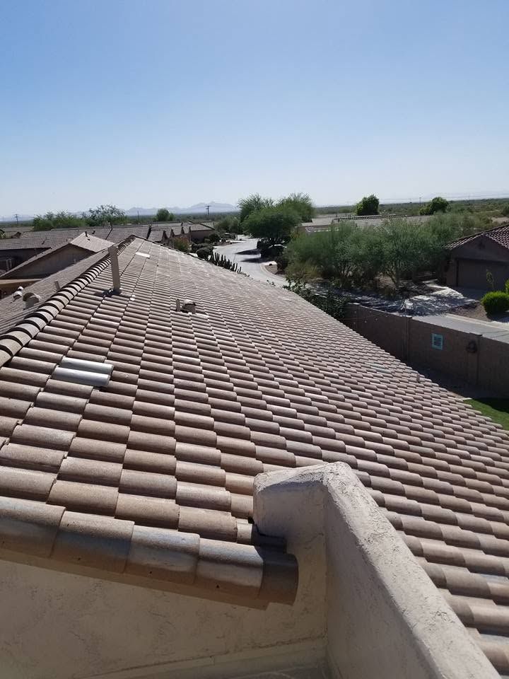 View from a tiled roof over a suburban neighborhood under a clear blue sky