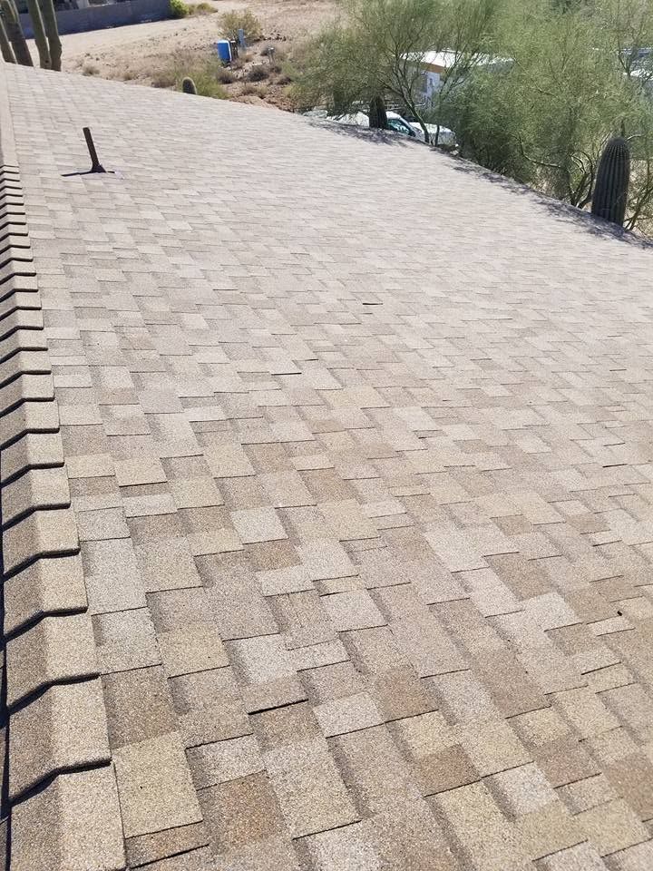 Brick-paved rooftop walkway beside desert landscaping and distant mountains