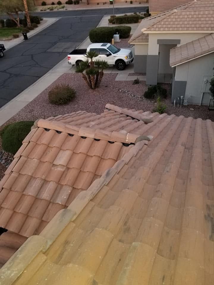 View from a tiled roof over a suburban street and driveway with a white car and desert landscaping