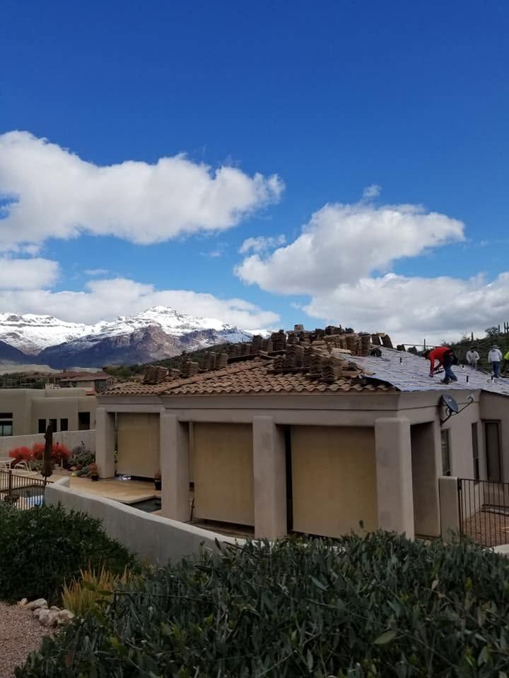 Rooftop terrace with clouds, mountains in the distance, and a person in a red jacket on the roof