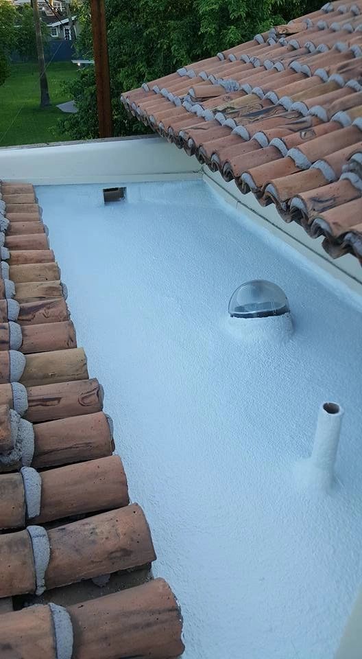 White rooftop terrace bordered by terracotta tiles, with a small dome vent and pipe opening.