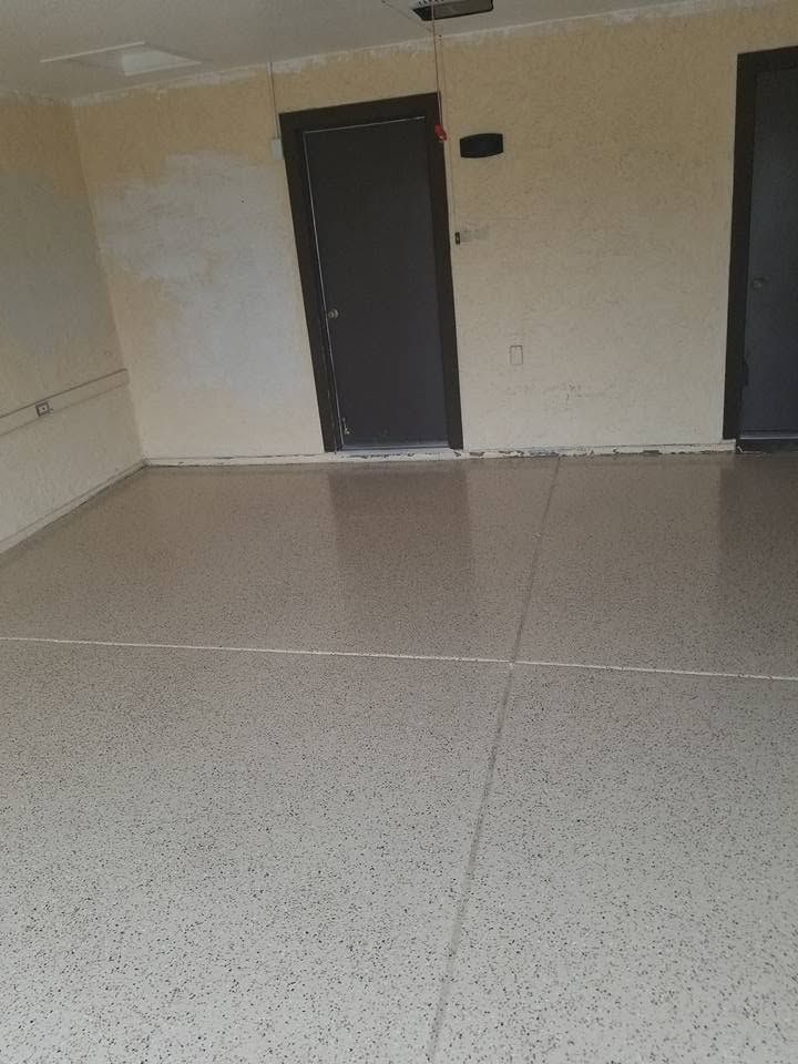 Empty tiled room with beige walls and two dark doors.