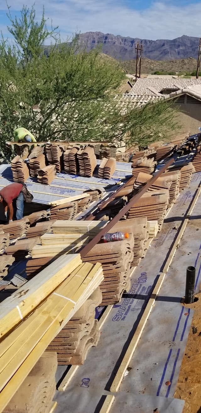 Construction site with wooden forms and lumber on a roof, mountains in the background