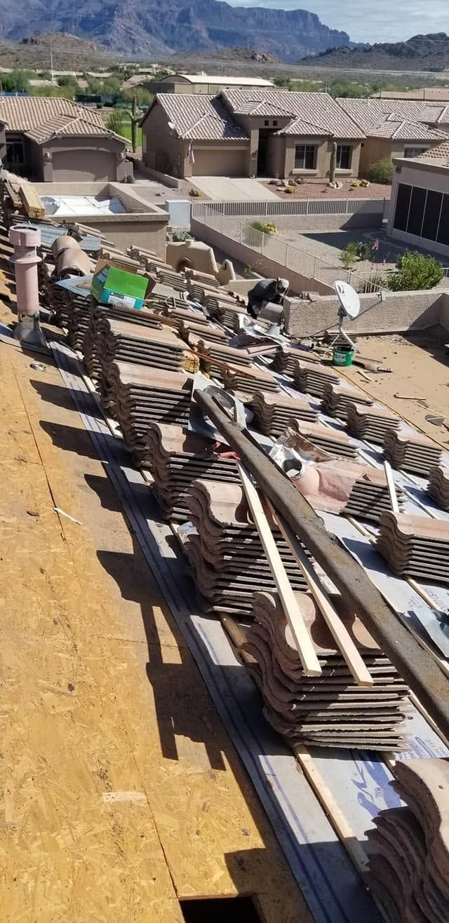Construction materials stacked beside desert homes under development, with mountains in the background