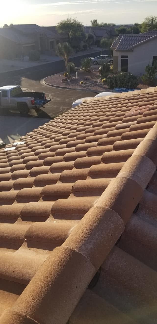 Sunlit terracotta roof tiles overlooking a suburban neighborhood at sunset