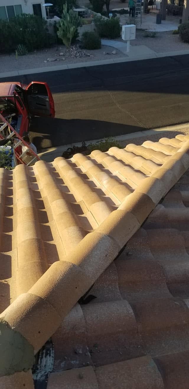 Long yellow corrugated panel laid diagonally across a tiled roof near a street.