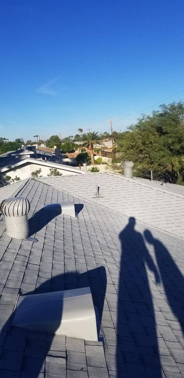 Rooftop with white tiles, a blue chair, and long shadows under a clear blue sky