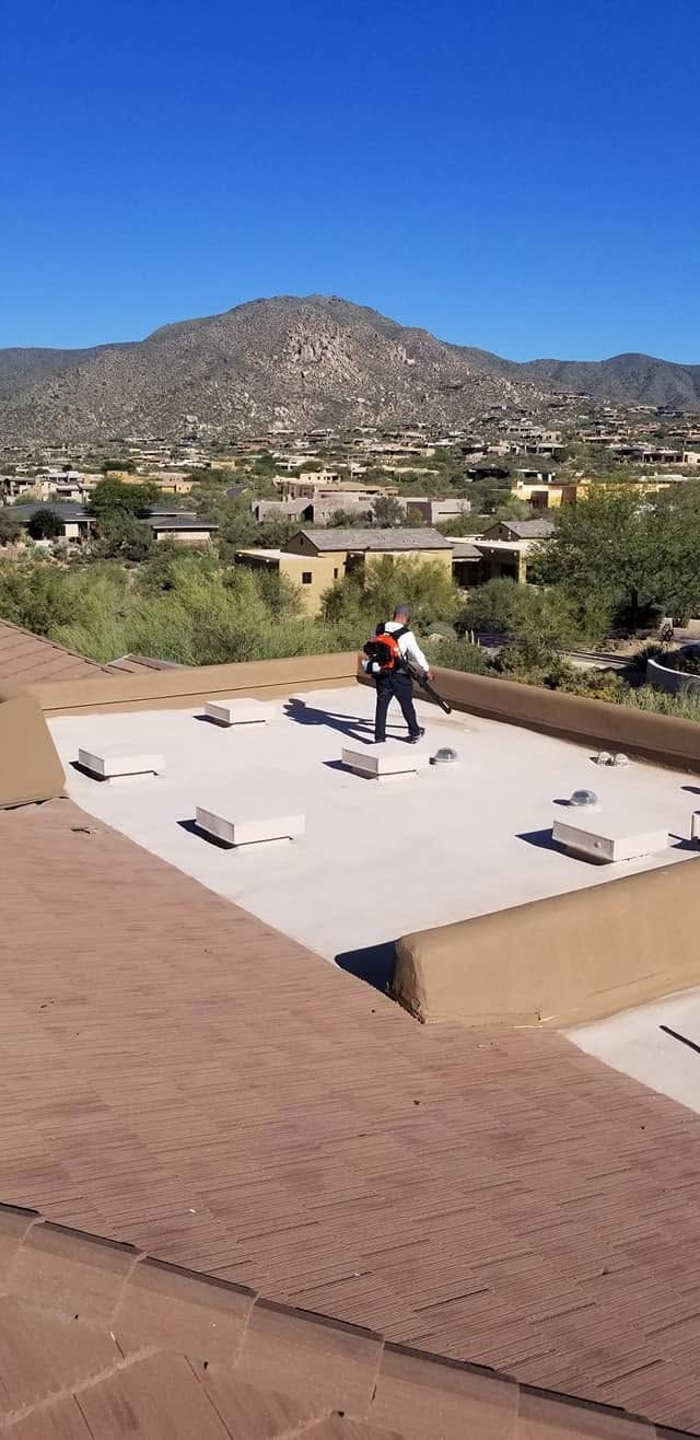 Person on a rooftop near rooftop equipment with mountains and houses in the background