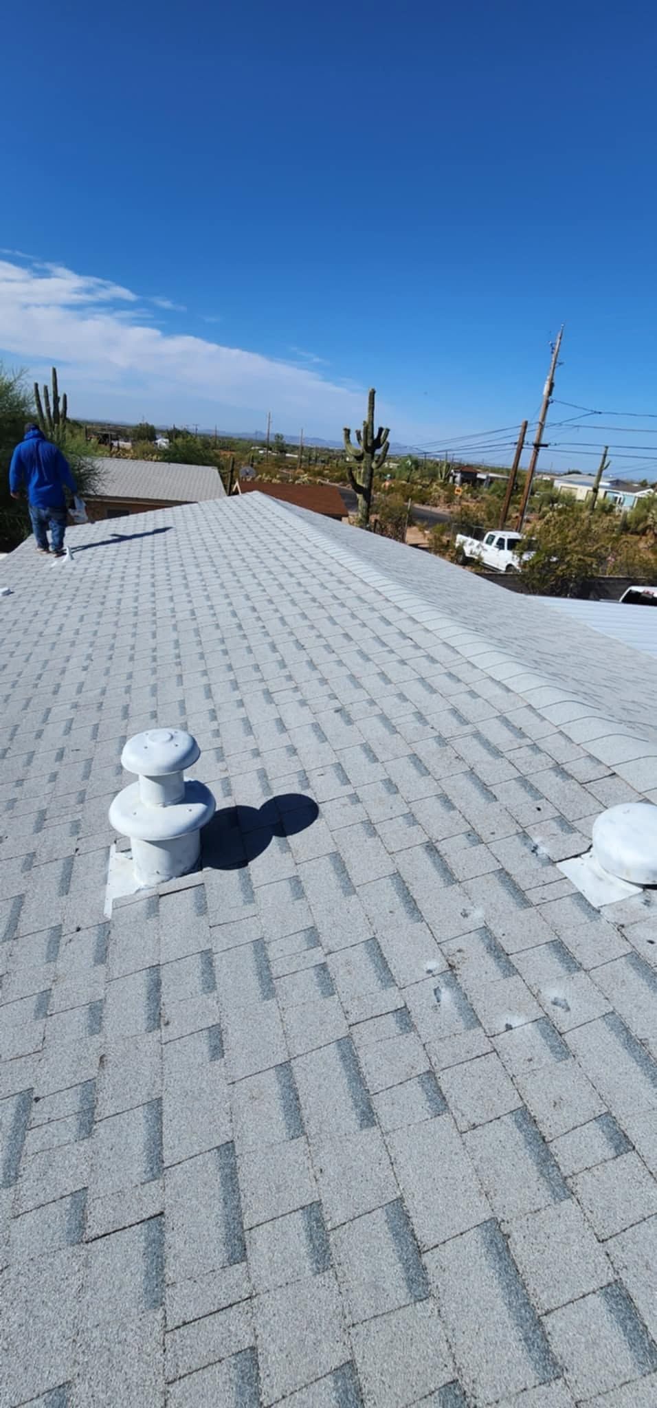 Rooftop with white gravel, blue sky, and distant buildings on a sunny day