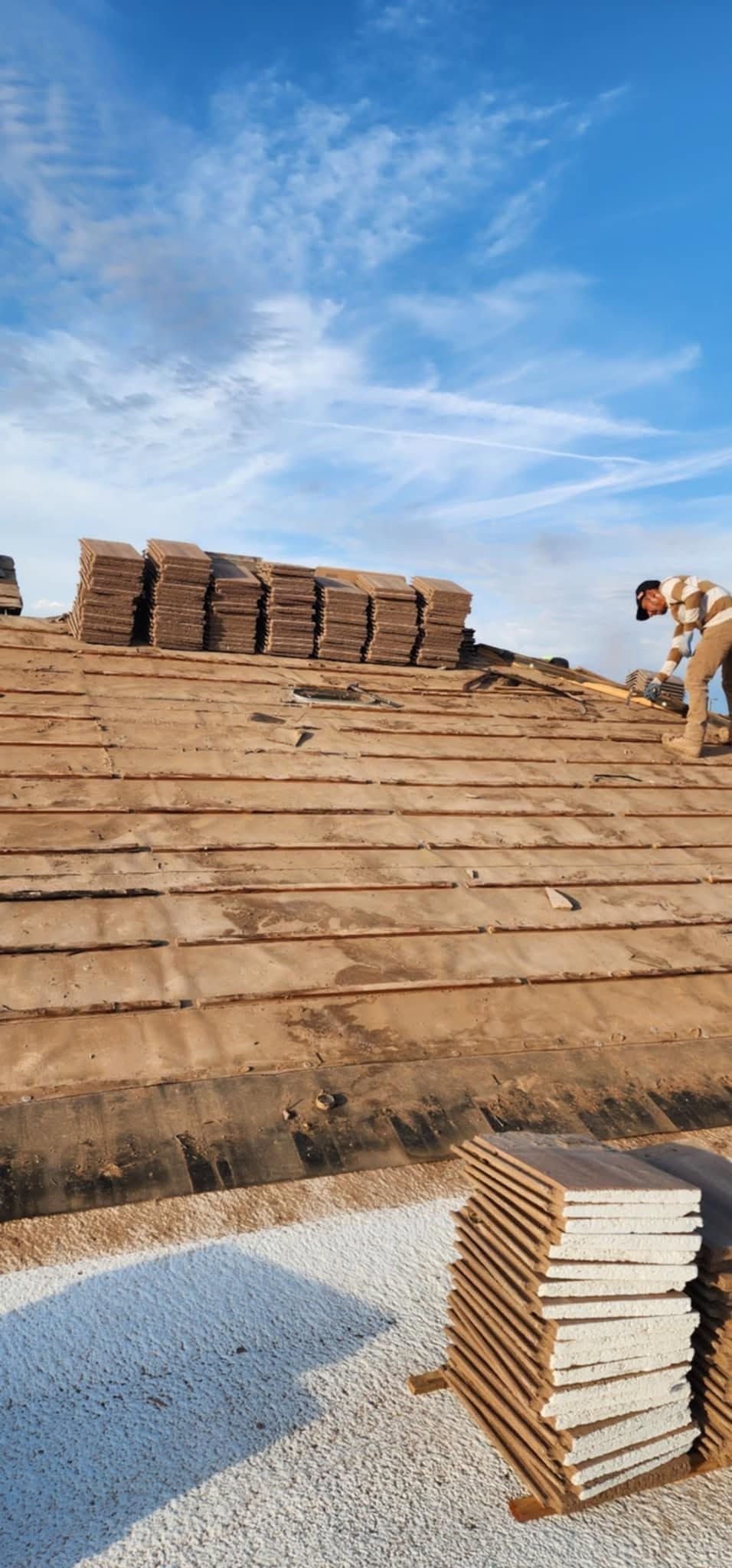 Stacks of bricks in a sandy construction yard under a blue sky