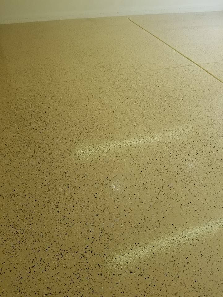 Close-up of a beige speckled floor with bright reflected light lines.