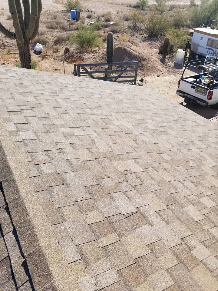 Stone-paved driveway overlooking a dry hillside, with a gate and utility vehicle at the side.