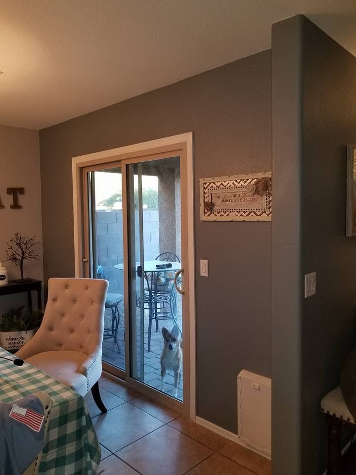 Living room with sliding glass door, tufted chair, and tiled floor leading to an outdoor patio.