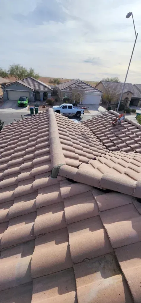 Reddish-brown tiled roof with a rooftop antenna, overlooking suburban houses and parked cars