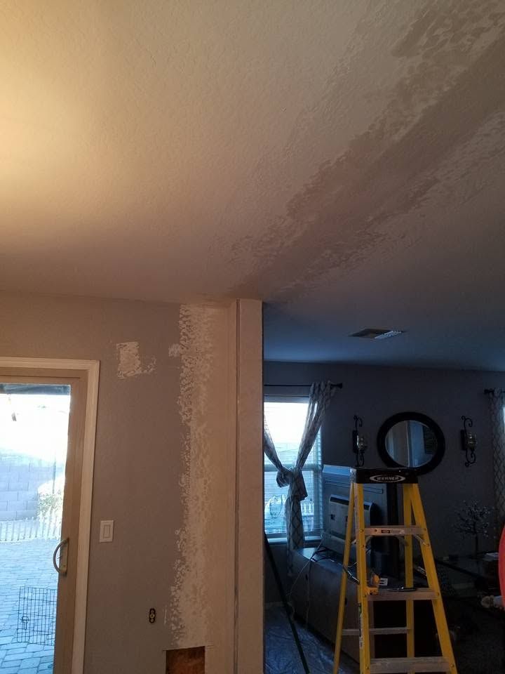 Interior room under renovation with a yellow ladder, unfinished ceiling, and blue-lit window in the background