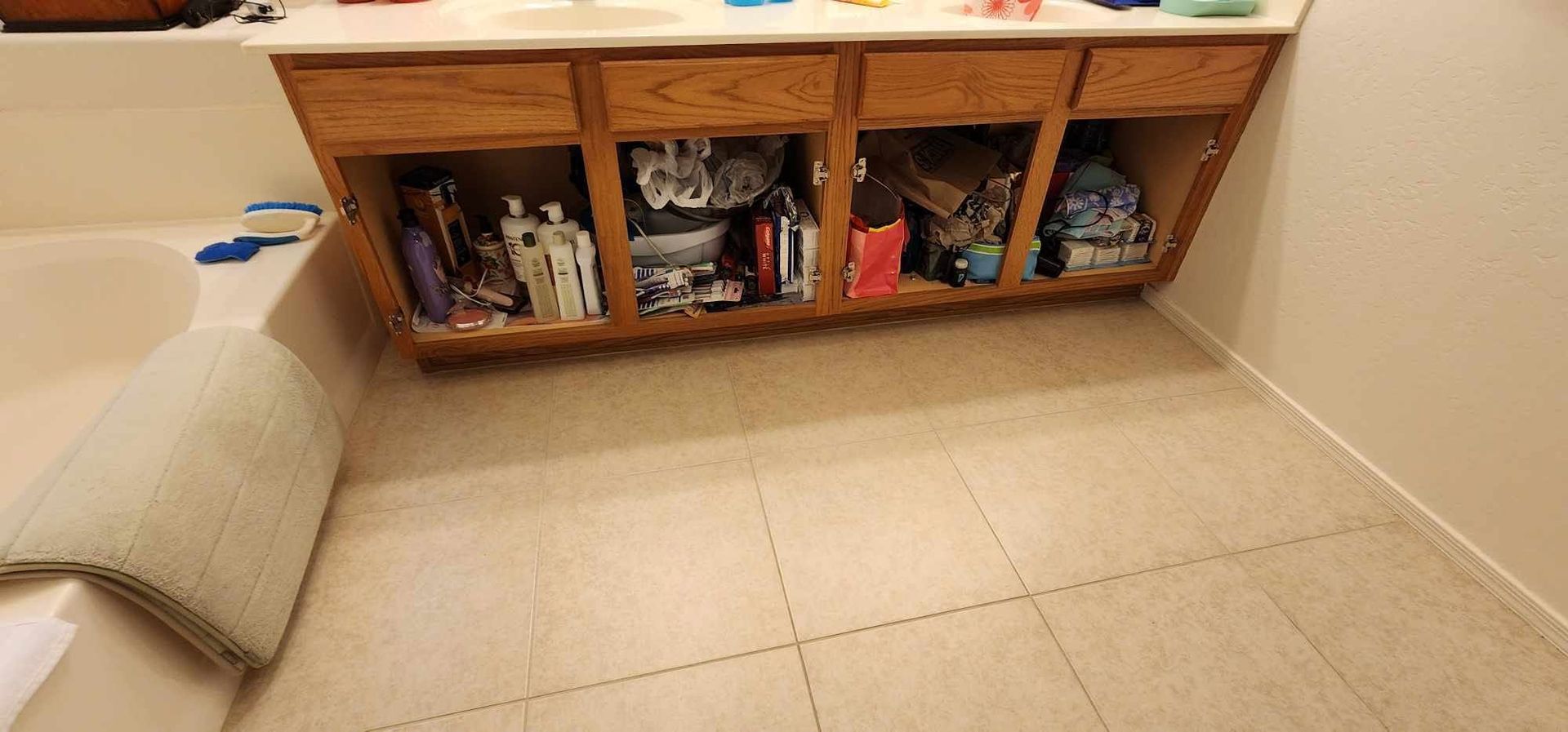 Sofa beside low wooden cubbies filled with toys and books in a tiled room
