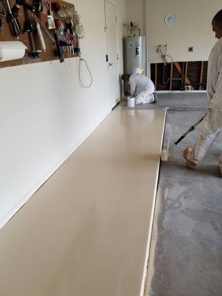 Worker installing a glossy beige floor in a hallway under renovation