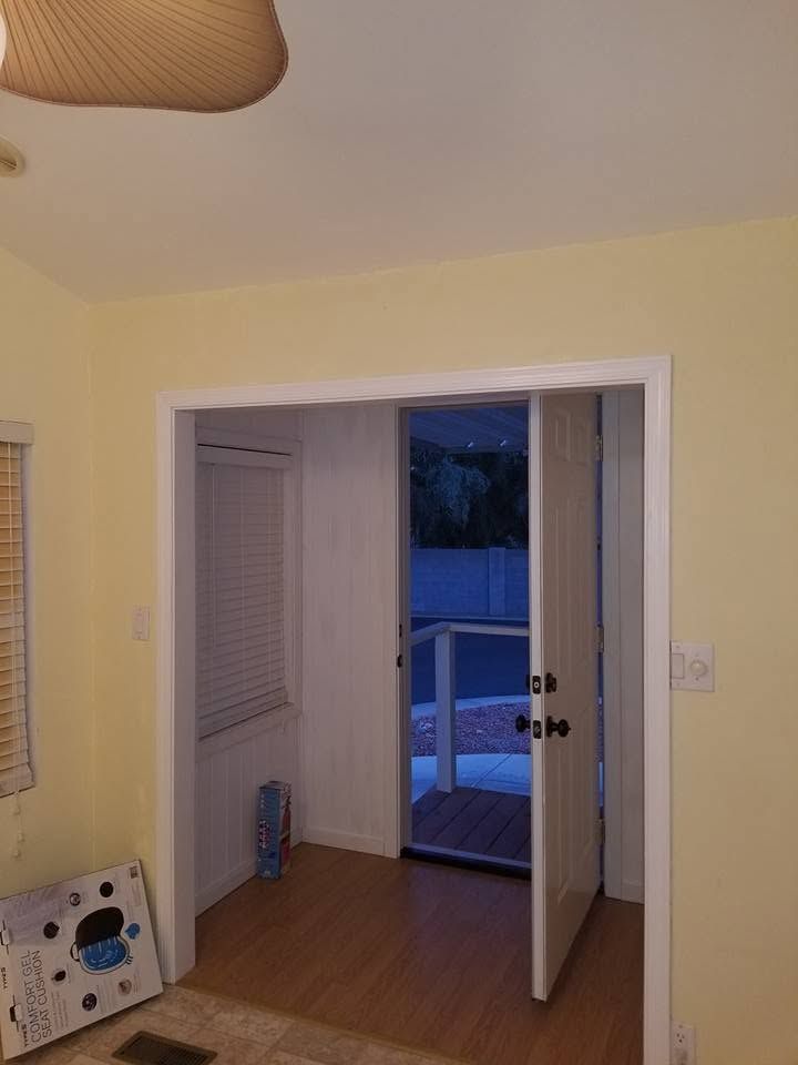 Small room with yellow walls, open double doors, and a view of a deck outside.