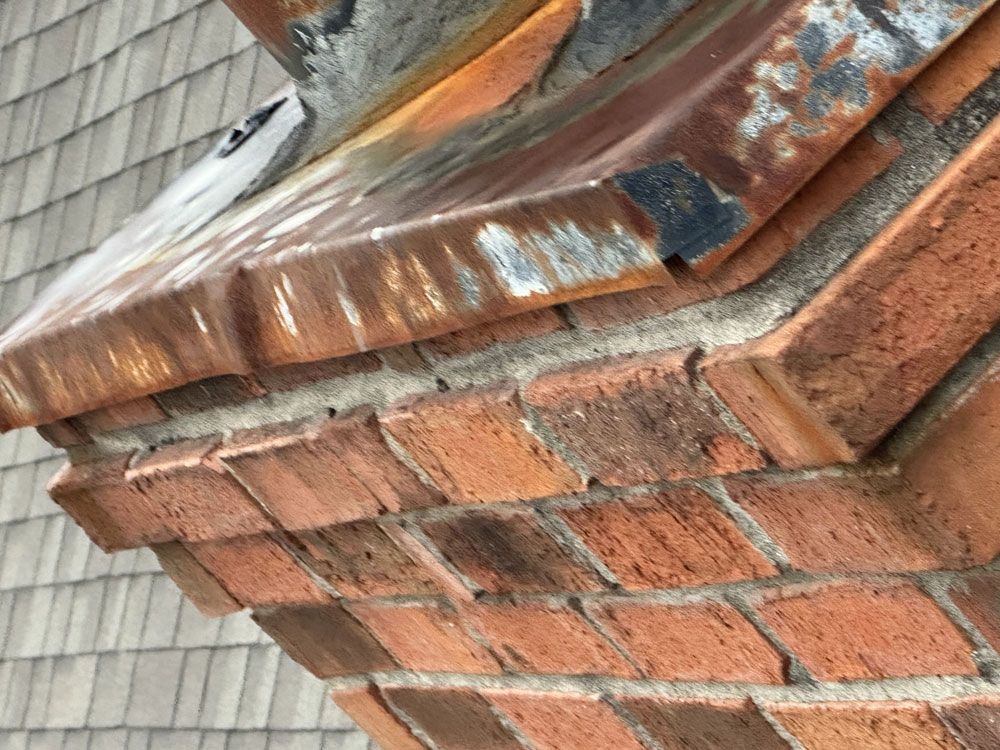 A close up of a brick chimney on a roof.