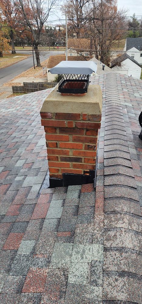 A brick chimney is sitting on top of a brick patio.