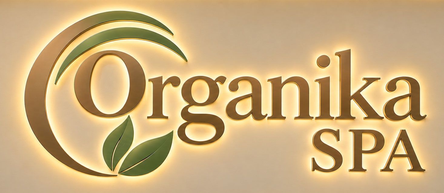 Organika Spa logo with gold text, green leaf, and circular swoosh on a beige background